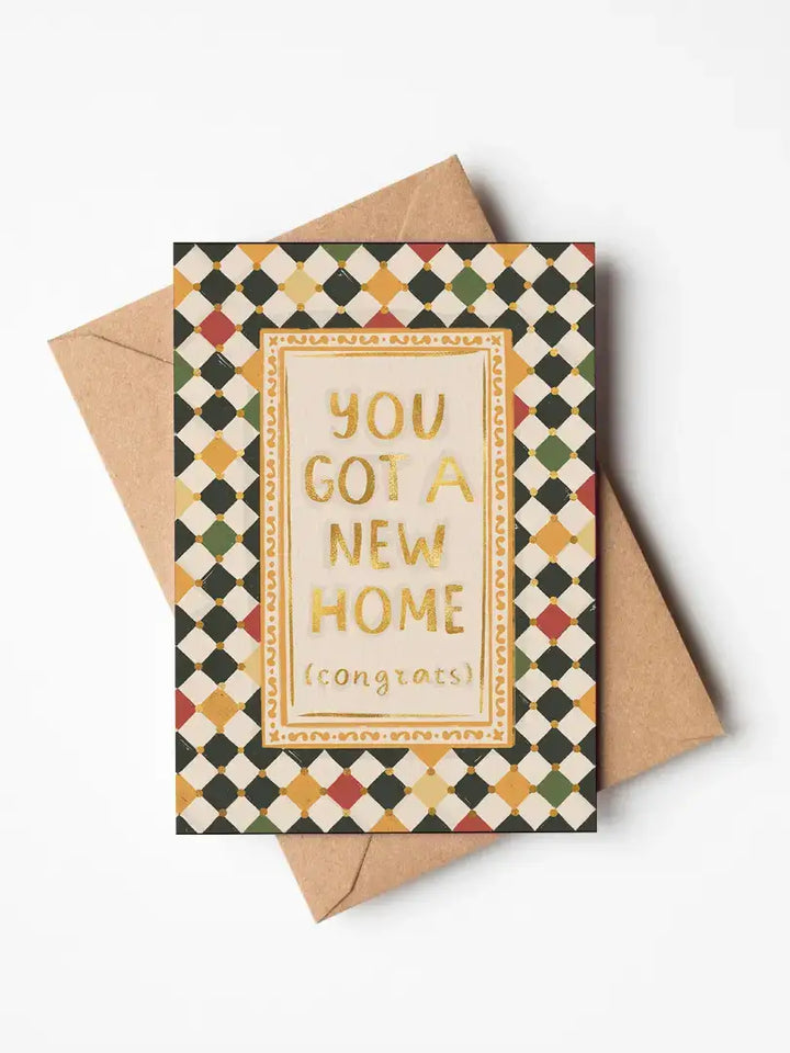 Jenna Crush new home greetings card featuring gold foil text and harlequin check design on premium card stock.