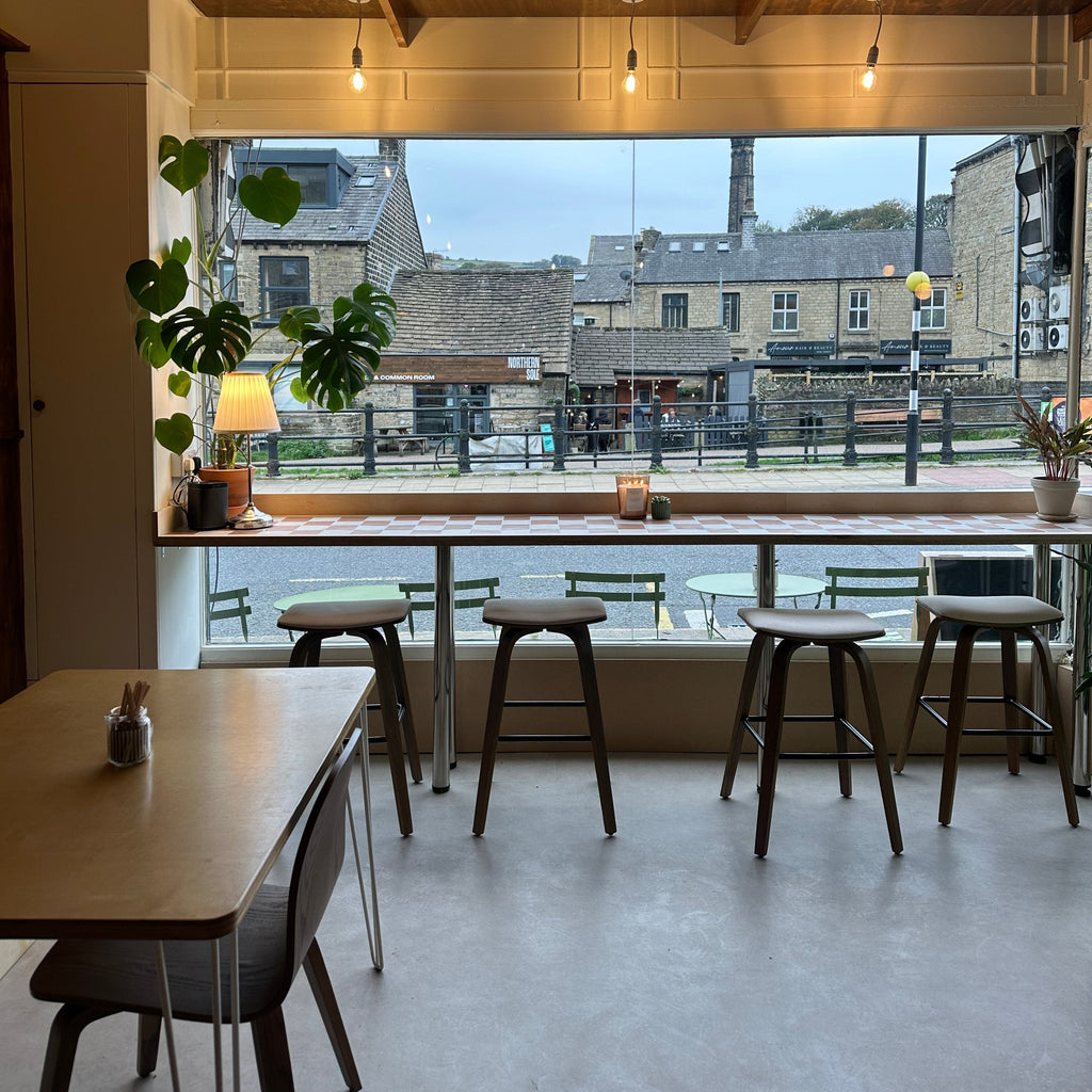 Modern interior with glass wall, chairs, and a view of buildings outside.
